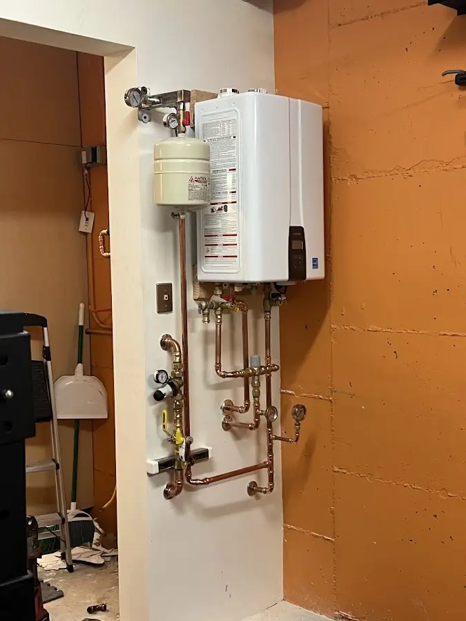 Plumbing technician inspecting water heater connections in Idaho Falls